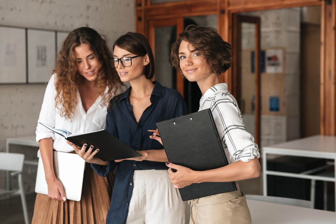 Three professional women reviewing documents